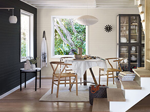Modern charcoal dining room with wishbone chairs and cream contrasting walls with rug on floorboards